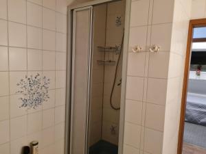 a shower in a bathroom with white tiles at NEU! Ferienwohnung zum Anker in Heeslingen +10 photos
