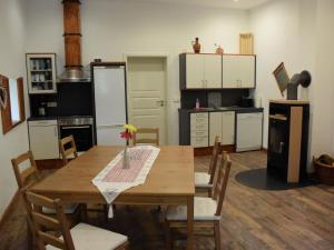 kuchnia z drewnianym stołem i krzesłami oraz kuchnia z białymi szafkami w obiekcie NEU! Moderne FeWo Nähe Plauer See 