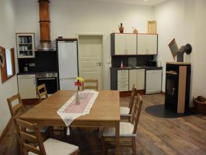 a kitchen with a wooden table with chairs and a kitchen with white cabinets at NEU! Moderne FeWo Nähe Plauer See in Preddöhl