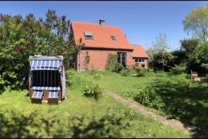 a house with a solar panel in the yard at NEU! Ferienhaus mit Naturgarten in Gleschendorf