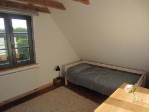 a bedroom with a bed and a table and a window at NEU! Ferienhaus mit Naturgarten in Gleschendorf