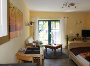 ein Schlafzimmer mit einem Bett und ein Wohnzimmer mit einem Tisch in der Unterkunft NEU! FeWo Haubentaucher 600 Meter vom Strand in Prerow