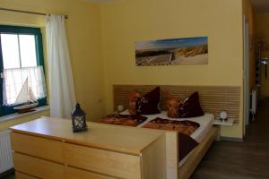 1 dormitorio con 2 camas, escritorio y ventana en NEU! FeWo Haubentaucher 600 Meter vom Strand en Prerow