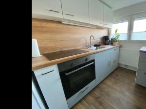 a kitchen with white cabinets and a sink and a stove at NEU Ferienwohnung Walsrode in Walsrode