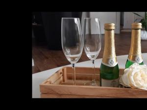 two champagne glasses in a wooden tray on a table at NEU Ferienwohnung Walsrode in Walsrode