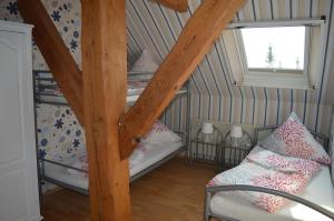 a attic room with two bunk beds and a window at NEU! Hennings Ferienhof in Neßmeraltendeich