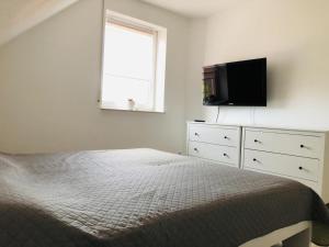 a bedroom with a bed and a flat screen tv at Schicke Ferienwohnung Victorbur in Südbrookmerland