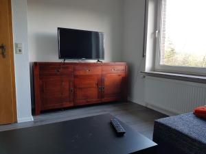 a living room with a television on a wooden dresser at NEU Ferienwohnung Kropp OG - Links in Kropp