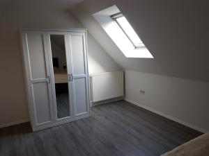 an attic room with a skylight and a door with a mirror at NEU Ferienwohnung Kropp OG - Links in Kropp