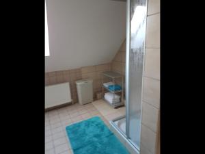 a small bathroom with a shower and a blue rug at NEU Ferienwohnung Kropp OG - Links in Kropp