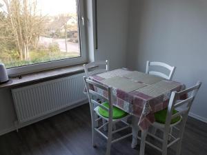 a table and chairs in a room with a window at NEU Ferienwohnung Kropp OG - Links in Kropp