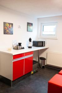 uma cozinha com um balcão vermelho e branco em NEU! Moderne Ferienwohnung Knüllwald em Knüllwald