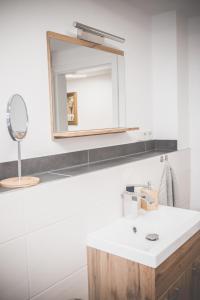 a bathroom with a white sink and a mirror at NEU! Moderne Ferienwohnung Knüllwald in Knüllwald +16 photos