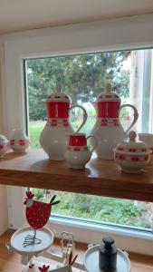 a shelf filled with red and white vases and a window at NEU! Ferienwohnung Böhlitz Neun in Grimma