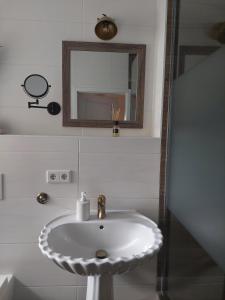 un lavandino bianco in un bagno con specchio di NEU! Ferienwohnung Böhlitz Neun a Grimma