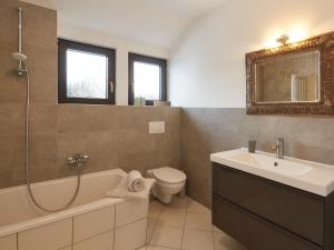 een badkamer met een wastafel, een bad en een toilet bij NEU! Ferienwohnung im Gottesgarten am Obermain in Hochstadt am Main
