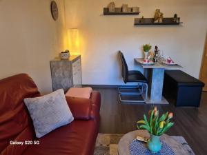 ein Wohnzimmer mit einem Sofa und einem Tisch in der Unterkunft NEU! Ferienwohnung Eulennest in Staudernheim