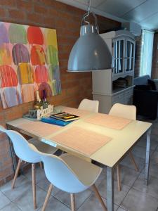 NEU! Ferienhaus Zijper 24 في Burgerbrug: طاولة غرفة الطعام مع الكراسي وضوء رائع