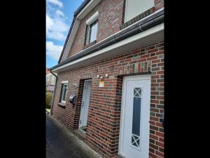 a brick building with a door on the side of it at NEU! Ferienhaus Küstenliebe in Harlesiel