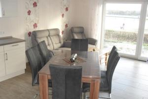 a kitchen and dining room with a table and chairs at Ferienhaus Doris Seeblick in Tannenhausen