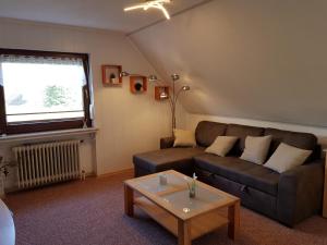 uma sala de estar com um sofá e uma mesa em NEU! Ferienwohnung Ramke OG em Lilienthal