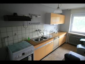 een kleine keuken met een wastafel en een fornuis bij NEU! Ferienwohnung im Herzen der Pfalz in Kaiserslautern