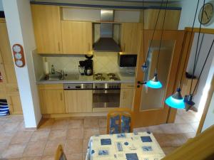 cocina con armarios de madera, mesa y fogones en NEU Das Ferienhaus, en Dornumergrode
