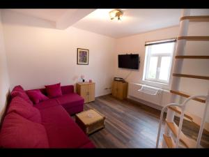 阿斯菲爾德的住宿－NEU! Schicke FeWo Alsfeld，客厅配有红色的沙发和一张双层床。