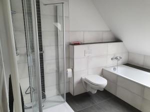 ein weißes Bad mit einem WC und einer Dusche in der Unterkunft NEU! Ferienwohnung Walnusstraum in Plaaz