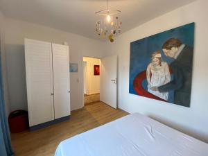 a bedroom with a painting on the wall and a bed at NEU! Ferienwohnung Atelier 7 in Klüsserath