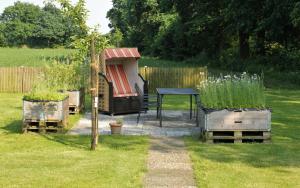 a garden with a table and some potted plants at NEU! Ferienwohnung im Leegmoor in Aurich