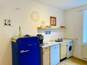 a kitchen with a blue refrigerator and a washing machine at NEU! Ferienwohnung Atelier 7 in Klüsserath