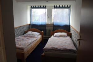 2 camas en una habitación pequeña con ventana en NEU! Ferienwohnung im Leegmoor, en Aurich