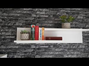 a white shelf on a brick wall with books and plants at NEU! Ferienwohnung am Bauna in Baunatal