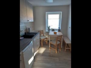 a kitchen with a sink and a table with chairs at NEU! Ferienwohnung Hanka in Crostwitz