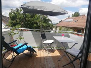 a patio with a table and two chairs and an umbrella at NEU Modernes Appartment Lara 