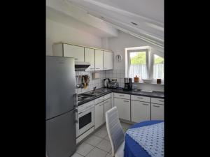 eine Küche mit weißen Geräten, einem Tisch und einem Fenster in der Unterkunft NEU Ferienwohnung Odenwald in Rimhorn