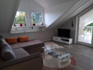 ein Wohnzimmer mit einem Sofa und einem TV in der Unterkunft NEU Ferienwohnung Odenwald in Rimhorn