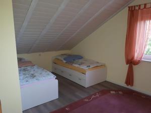 2 Betten in einem kleinen Zimmer mit Dach in der Unterkunft NEU Ferienwohnung Odenwald in Rimhorn