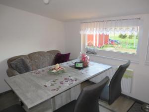 un salon avec une table, des chaises et un canapé dans l'établissement NEU Ferienhaus Torfmuttje nähe Norddeich mit Hund, à Upgant-Schott