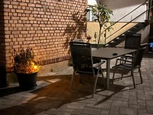 une table et des chaises sur une terrasse à côté d'un mur de briques dans l'établissement NEU! Ferienwohnung Nestblick, à Weilbourg