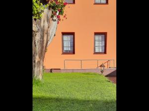 ein orangefarbenes Gebäude mit Fenstern und einem grünen Hof in der Unterkunft Zur alten Gurkeneinlegerei in Lübbenau