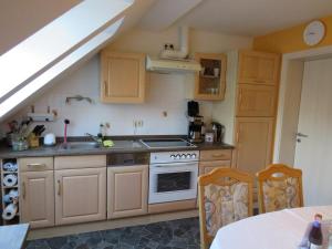 a kitchen with a stove and a sink and a table at FeWo Bergstadt Ehrenfriedersdorf in Ehrenfriedersdorf