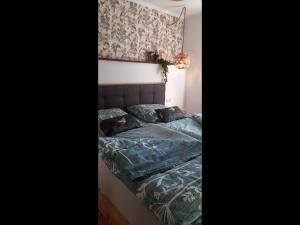 ein Schlafzimmer mit einem Bett mit blauer Bettdecke und Kissen in der Unterkunft Zur alten Gurkeneinlegerei in Lübbenau