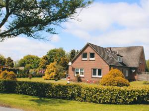 una casa de ladrillo con un patio paisajista en NEU! Ferienhaus am Moor, en Wiesmoor