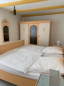 een slaapkamer met een groot bed met witte lakens bij NEU! FeWo History Aschersleben in Aschersleben