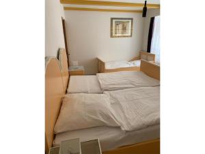 a small bedroom with a bed with white sheets at NEU! FeWo History Aschersleben in Aschersleben