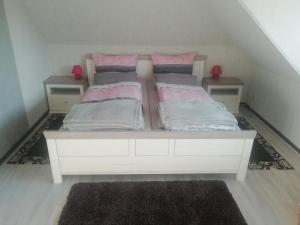 a white bed with two pillows on it in a room at NEU! Ferienwohnung Nordfriesland in Achtrup