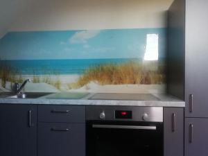 a kitchen with a window with a view of the beach at NEU! Ferienwohnung Nordfriesland in Achtrup