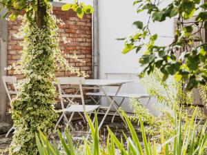 a table and chairs in front of a brick wall at NEU! Studio Beim Kirchschuster in Schernfeld